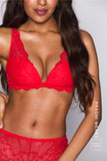 A woman wearing a red lace push up bra paired with matching knickers 