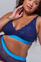 A woman wearing a dark blue lace fuller cup bralette paired with the matching briefs 
