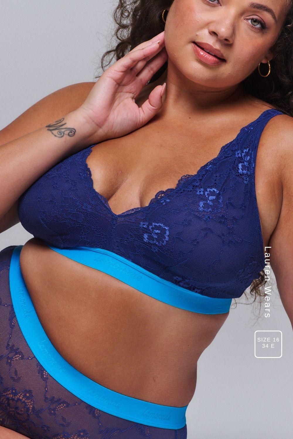 A woman wearing a dark blue lace fuller cup bralette paired with the matching briefs 