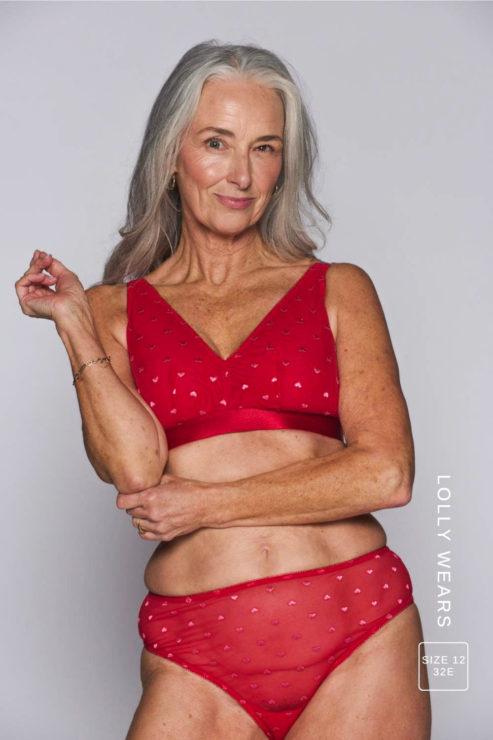 A woman modelling a red mesh fuller cup bralette with hearts on it paired with matching briefs 