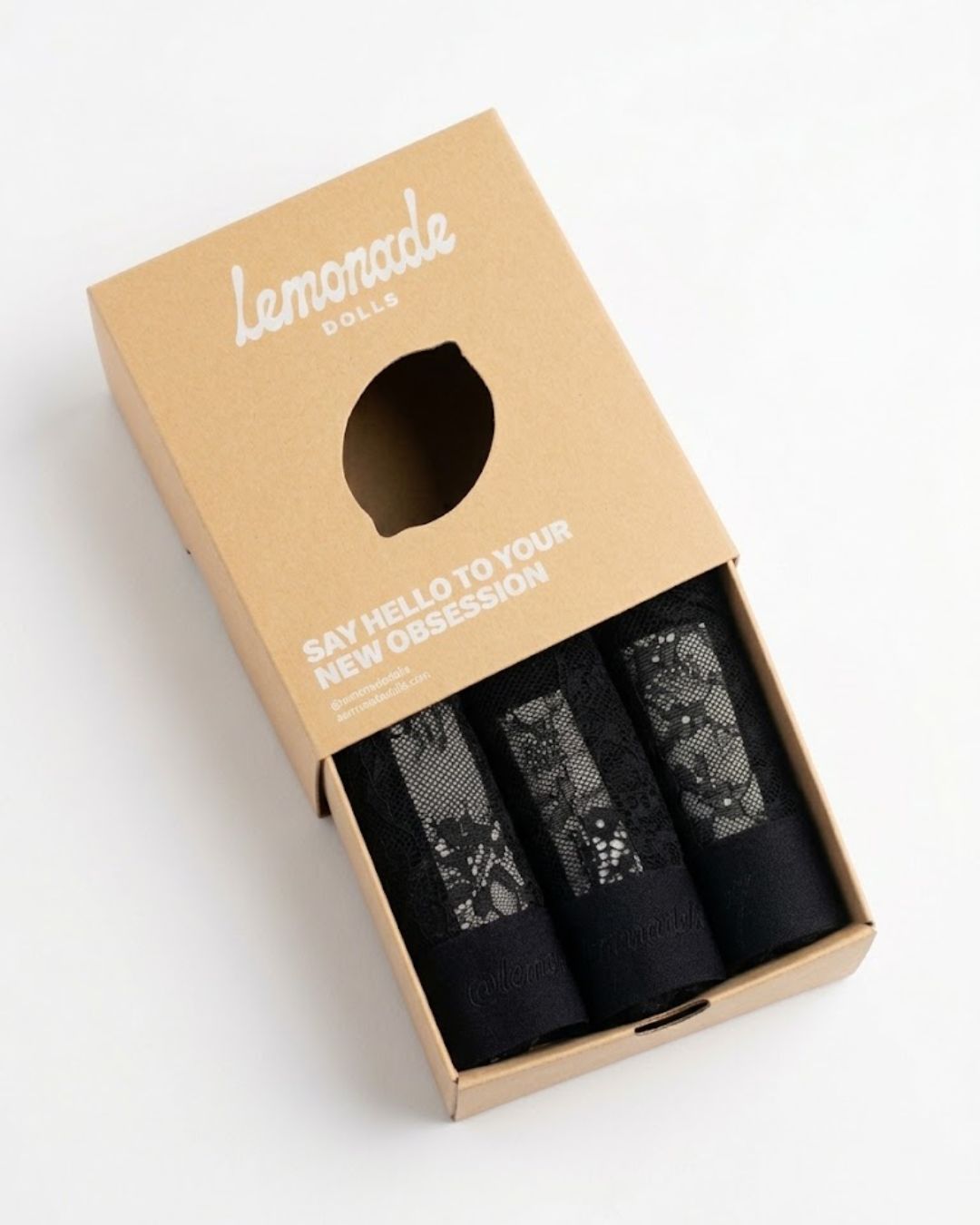 A lemonade dolls brand box half open showing three black lace briefs inside 