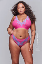 A woman wearing a pink and purple floral embroidered fuller cup bralette paired with the matching thong ^Lauren | Size: 34 E / 16