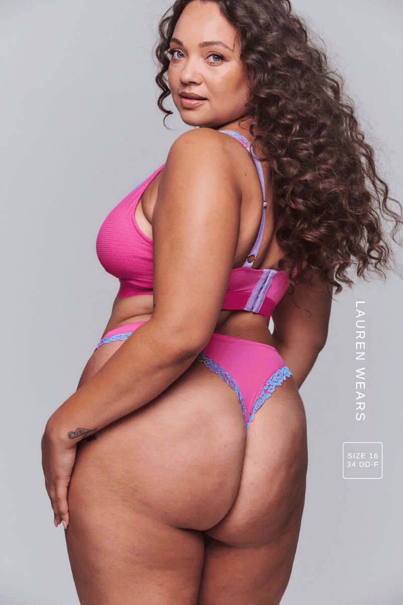 A woman standing with her back to wearing a pink and purple thong with the matching bralette 