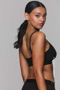 A woman wearing a black mesh fuller cup bralette paired with matching black mesh briefs 