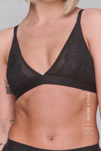 a woman modelling a black lace bralette 