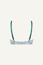 A ghost image of the back of a blue mesh bralette with small pink hearts on it and green straps 