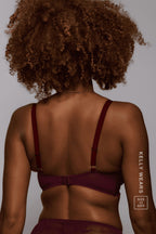 a woman standing with her back turned wearing a wine lace push up paired with a matching brief 