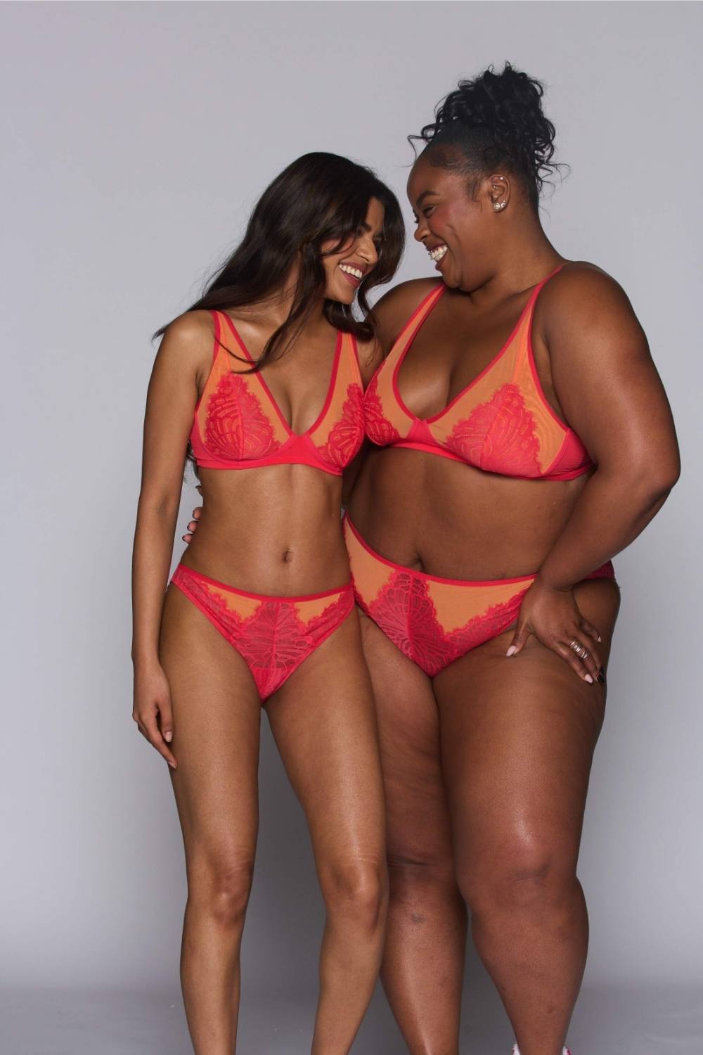 two woman modelling an orange and coral bralette paired with the matching brief 