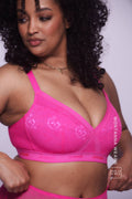 A woman wearing a neon pink lace fuller cup bralette paired with matching briefs 