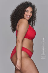 A woman standing with her side to wearing a red lingerie set 