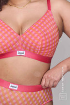 A close up image of a woman modelling a soft mesh fuller cup check print bralette paired with the matching brief