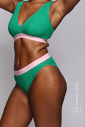 A close up image of a woman wearing a matching green and pink lace lingerie set ^Kelly | Size: 32 DD / 12