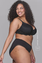 Woman wearing a black bra called The flex and a soft black Brief 