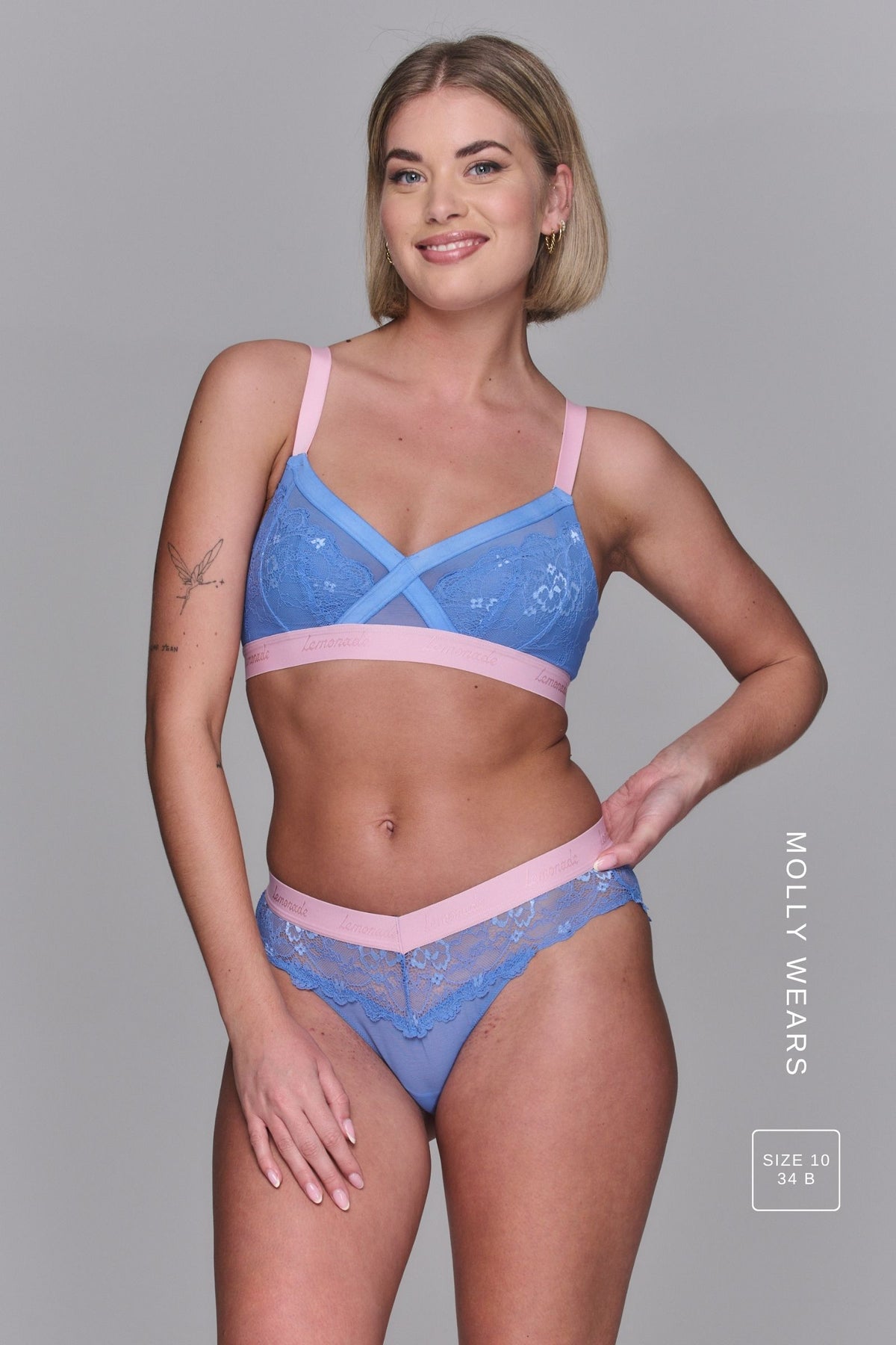 A woman wearing a pink and blue lace bra called The One paired with matching knickers ^Molly | Size: 34 B / 10