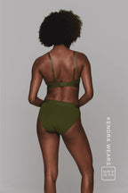 A woman standing with her back to wearing a matching khaki lingerie set 