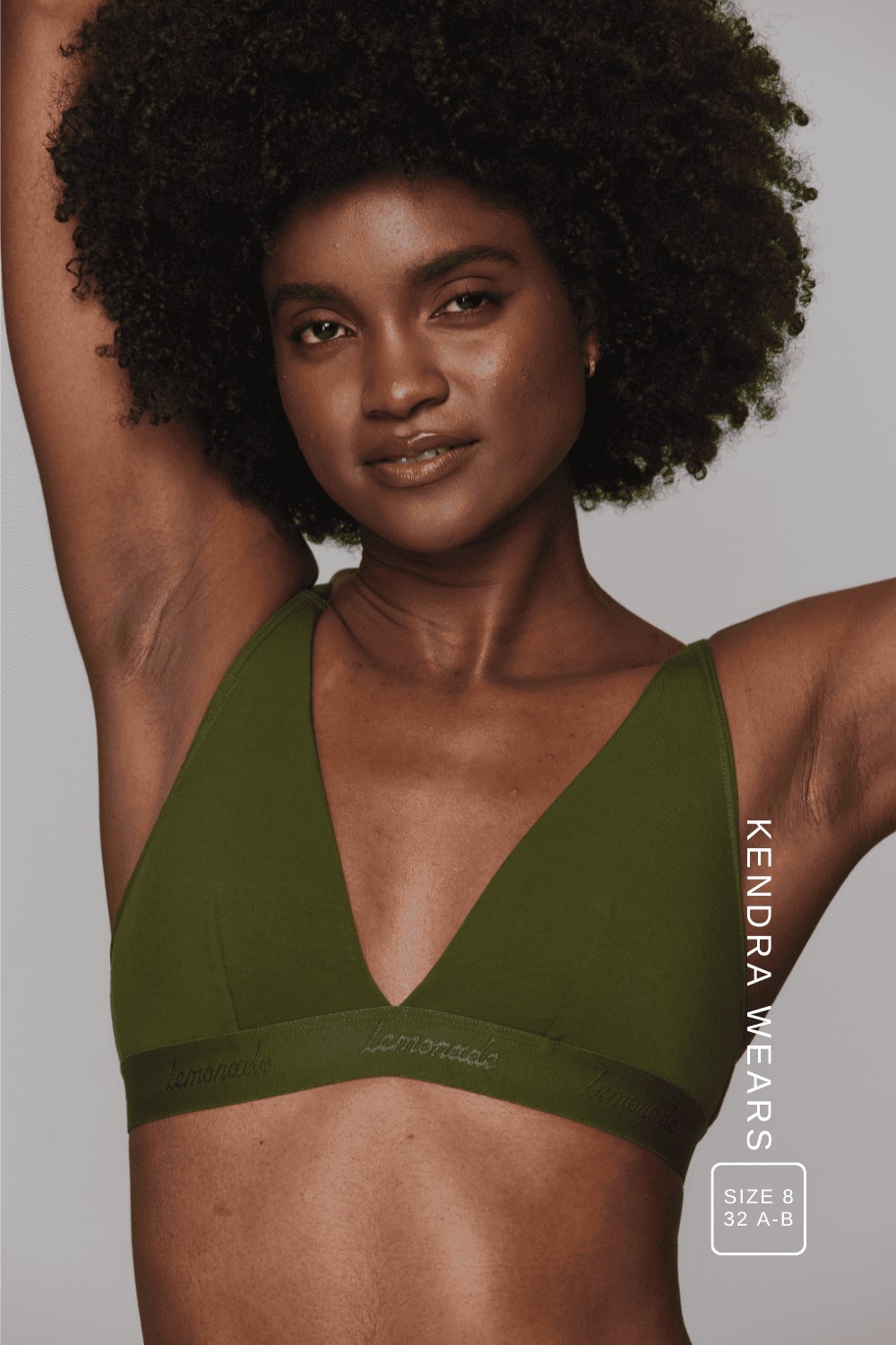 A woman wearing a khaki green mesh bralette 