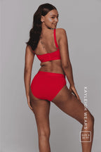 A woman wearing a red modal brief and a matching bralette 