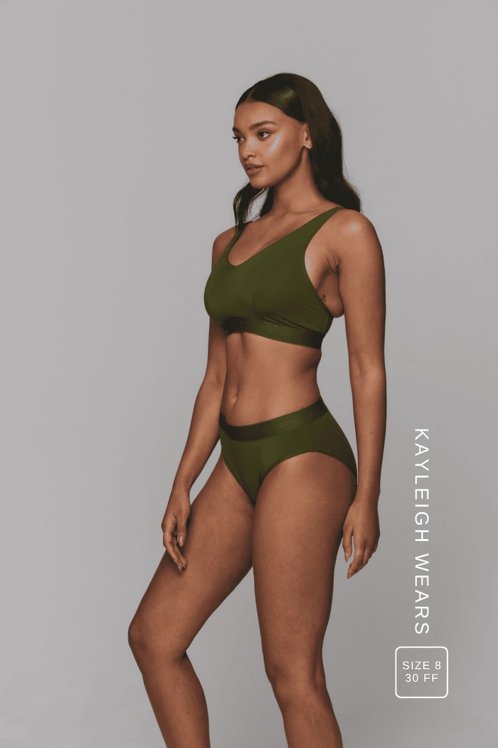 A woman standing with her side to wearing a matching khaki mesh lingerie set 