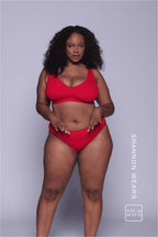 A woman wearing a red mesh fuller cup bralette paired with matching knickers 