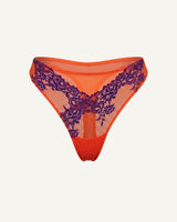 a ghost image of the front of a orange and purple embroidered lace thong 
