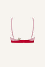 A ghost image of the back of a light pink and red ace bralette 