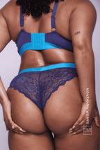 A close up image of the back of a woman wearing a navy blue lace brazilian 