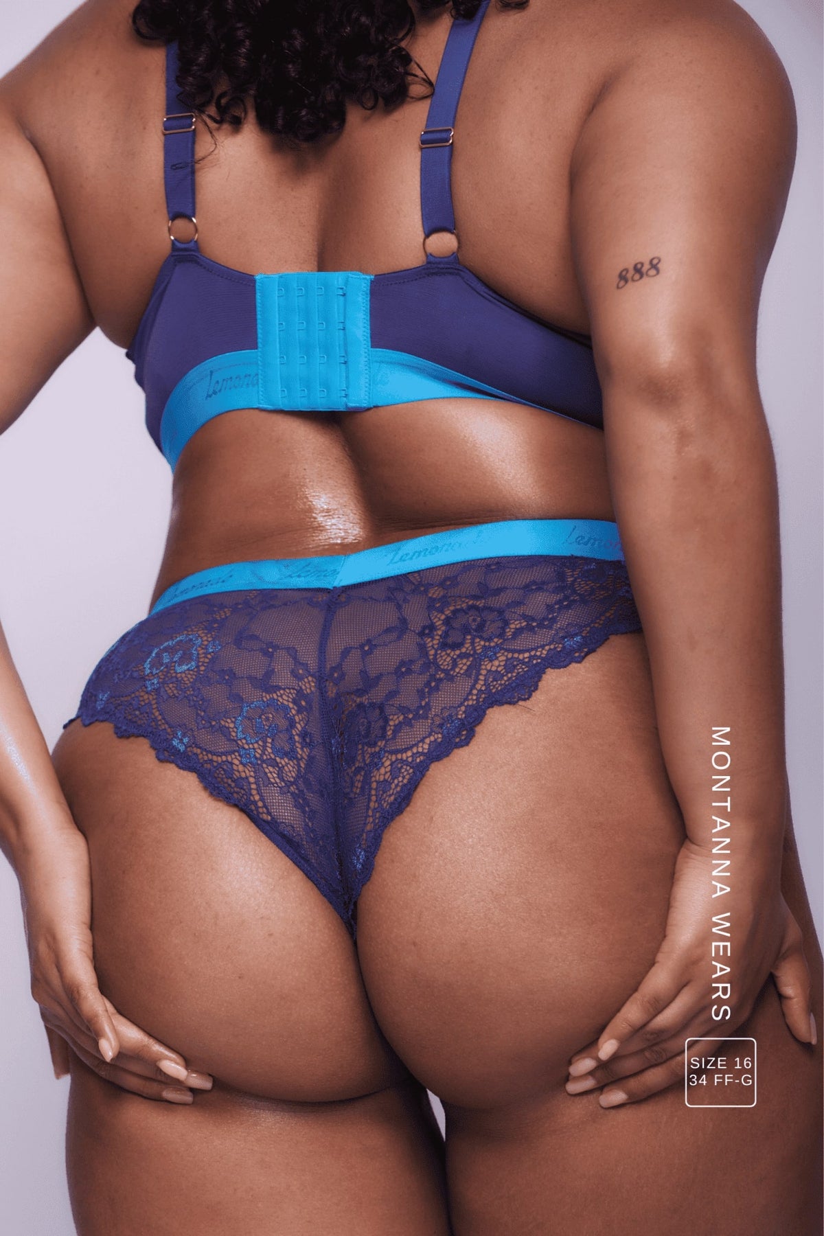 A close up image of the back of a woman wearing a navy blue lace brazilian 