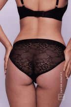 A close up image of a woman from the back, wearing a black lace brief 