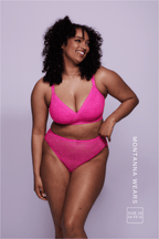 A woman wearing a neon pink lace fuller cup bralette paired with matching briefs 