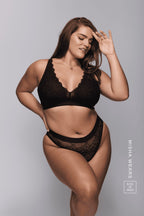 A woman wearing a lack lace highwaisted brazilian knicker paired with a matching fuller cup bralette 