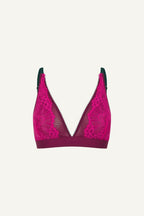 A ghost image of the front of a pink lace bralette with green details on it 
