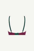 A ghost image of the back of a pink and green lace bralette 
