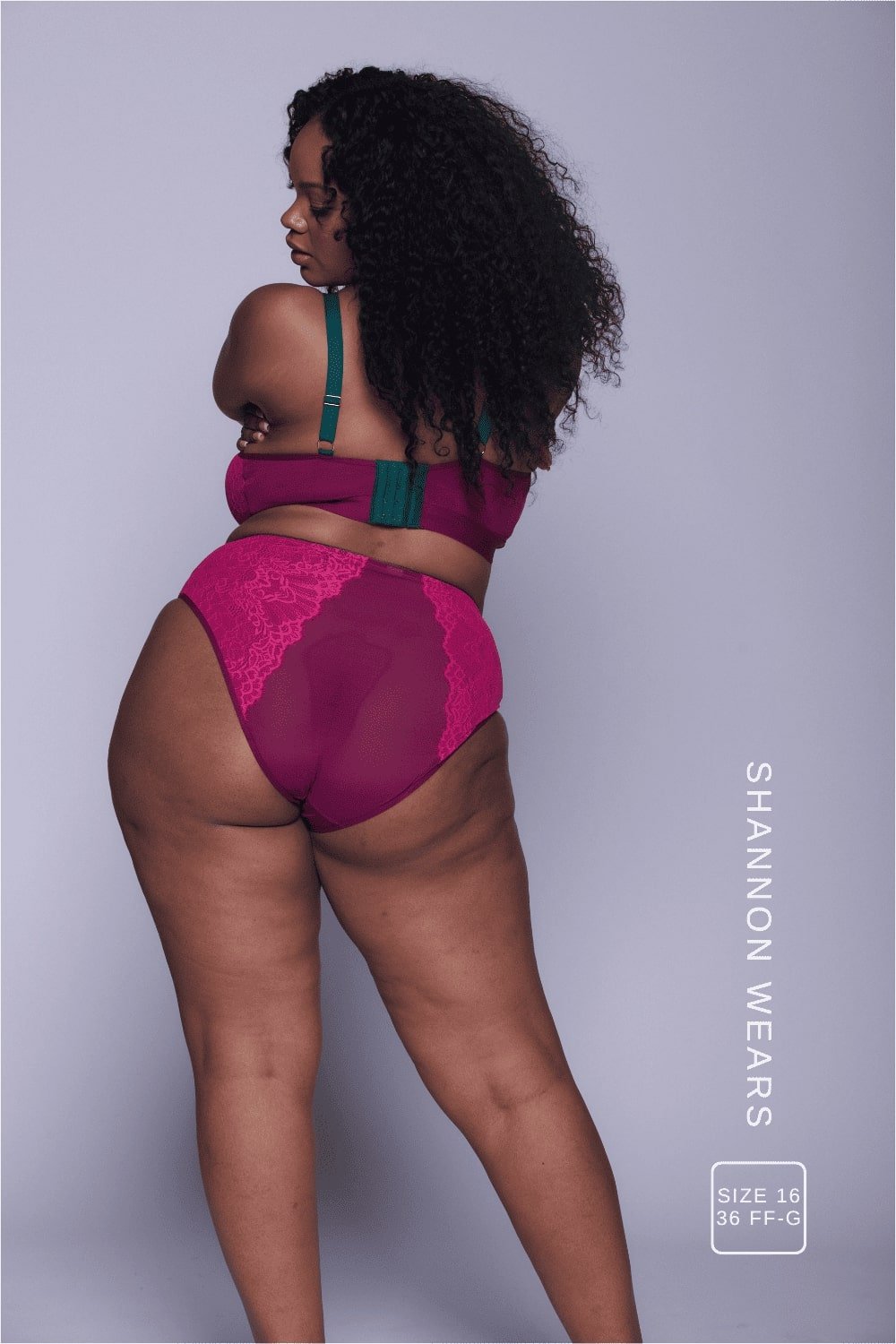 A woman standing with her back to wearing a pink lingerie set