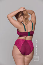 A woman standing with her back to wearing aa matching pink and green lingerie set 