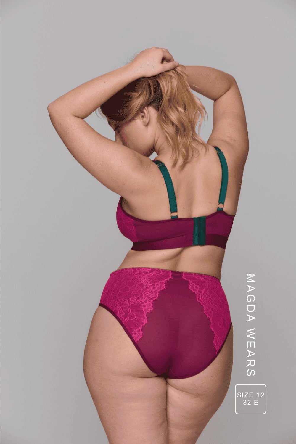 A woman standing with her back to wearing aa matching pink and green lingerie set 