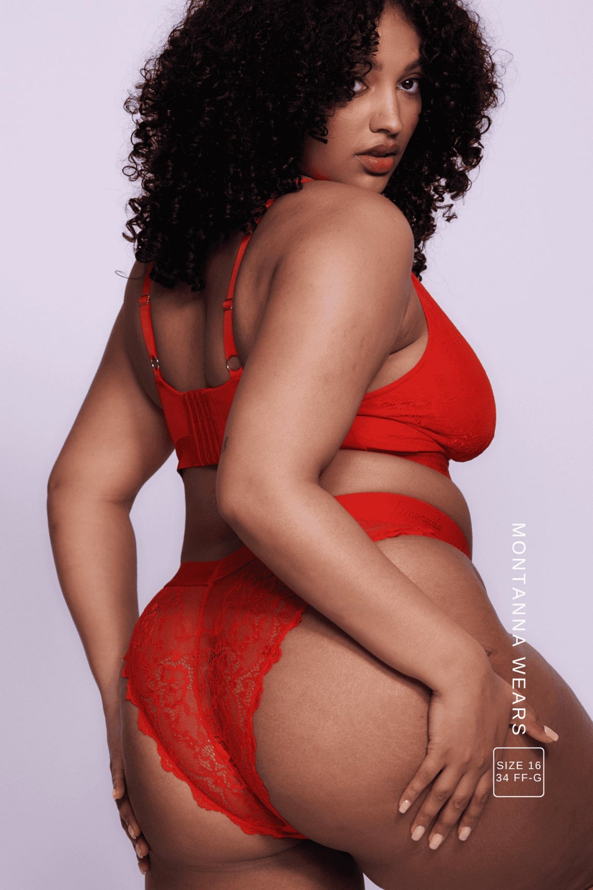 A woman standing with her side to wearing a red lace brazilian knicker 
