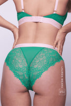 A close up image of a woman standing with her back to wearing a green lace brief 