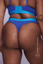 A close up image of a woman wearing a blue lace and mesh thong 