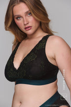 A woman wearing a dark green and black lace fuller cup bralette