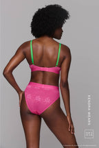 A woman standing with her back to wearing a pink lingerie set 